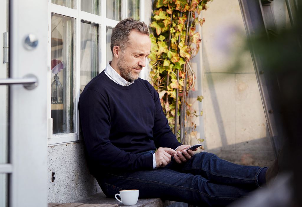 Hombre con aplicación de alivio de acúfenos en el móvil